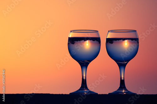 Glasses of white vine with reflections of houses and view to bea