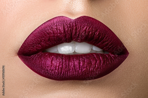 Photo Close up view of beautiful woman lips with purple matt lipstick