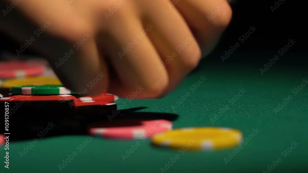 Close-up shot of female hands collecting poker chips off the table at casino Close-up shot of female hands collecting poker chips off the table at casino