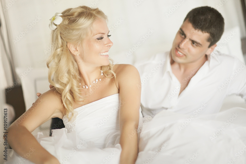 Lovely married couple teasing each other lying on bed.
