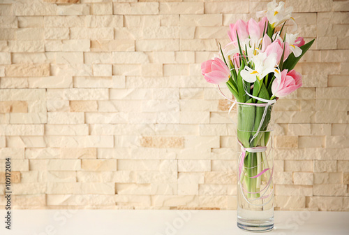 Beautiful bouquet of fresh flowers against brick wall background
