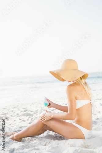 Blonde woman applying sun cream
