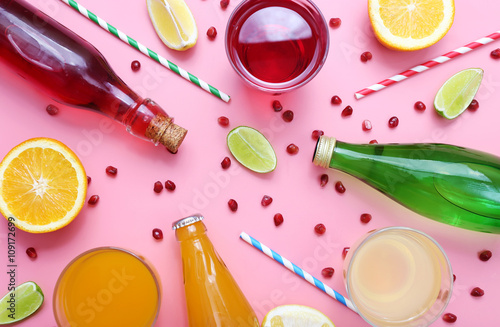 Different fruit drinks with fresh fruits on pink background