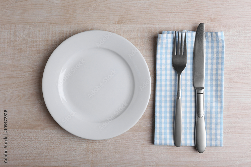 Empty plate with silver fork and knife on wooden background Empty plate with silver fork and knife on wooden background