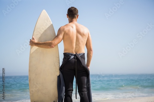 Handsome man holding surfboard