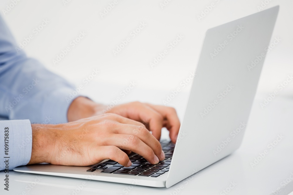 Mid-section of businessman working on laptop Mid-section of businessman working on laptop