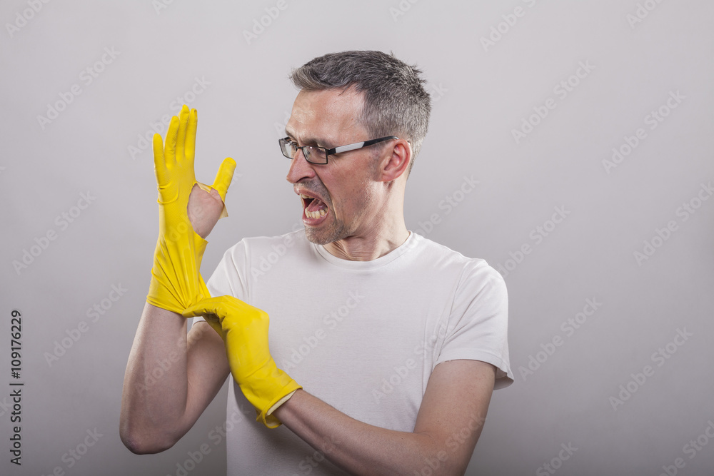 Man puts on yellow rubber gloves Man puts on yellow rubber gloves
