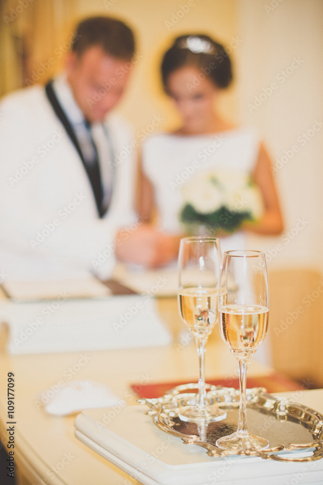 Wedding glasses are in the foreground. Blurred outlines newlywed Wedding glasses are in the foreground. Blurred outlines newlywed