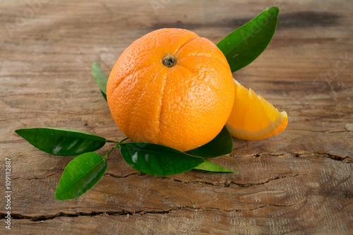 Oranges fruit with leaves on wooden background