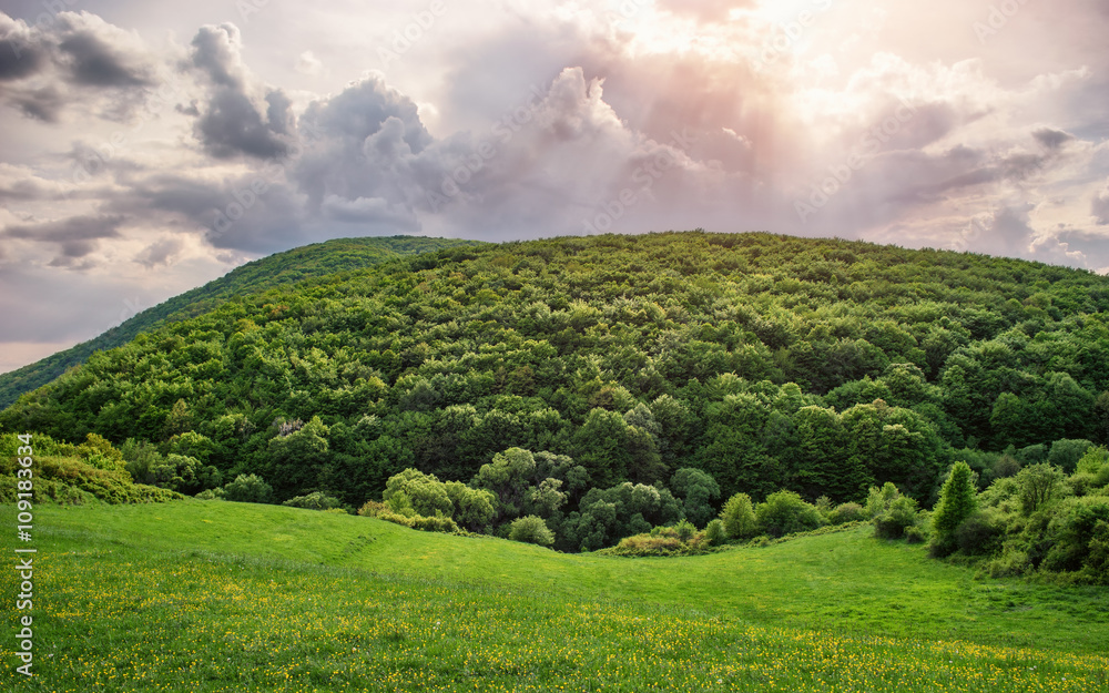 Beautiful cloudscape over the hill with sun rays Beautiful cloudscape over the hill with sun rays