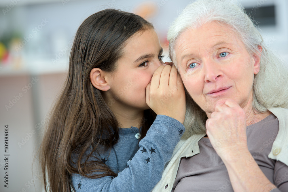 Little girl and grandma whispering secrets Little girl and grandma whispering secrets