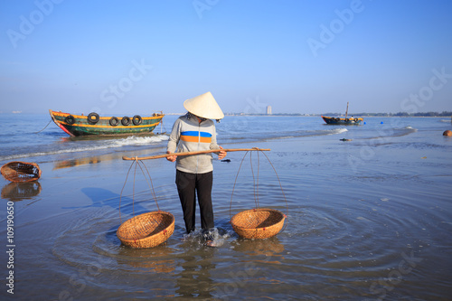 People with conical hat cleaning fish basket, at Long Hai townsh