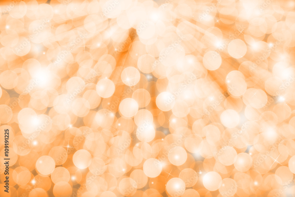 Gold glitter sparkles defocused rays lights bokeh abstract holiday background.