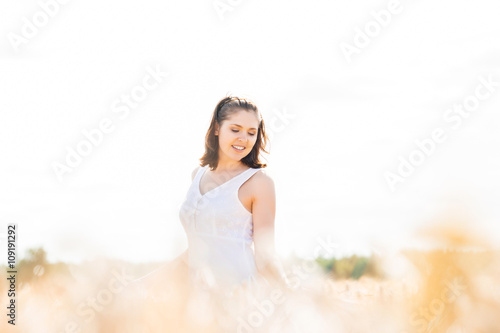 Young and happy woman in a meadow of rye