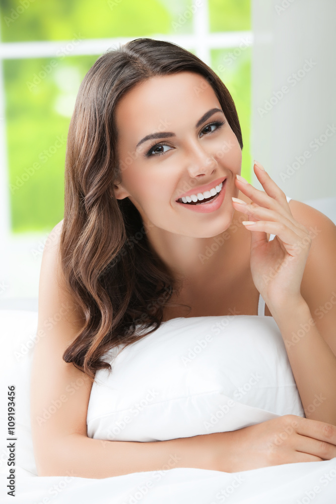 Young beautiful smiling woman waking up with pillow, at bedroom Young beautiful smiling woman waking up with pillow, at bedroom
