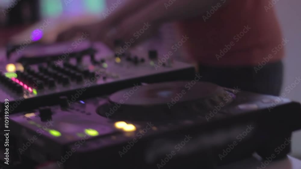 Hands of male dj turning controls on sound equipment, playing music in nightclub Hands of male dj turning controls on sound equipment, playing music in nightclub