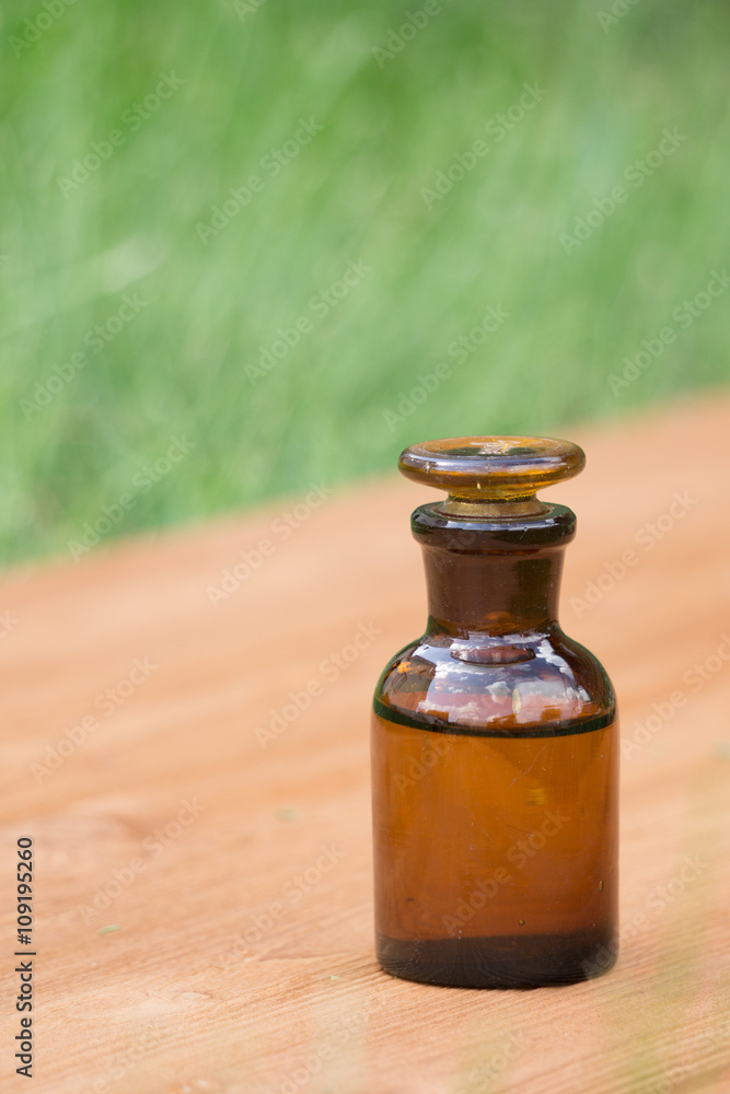 little brown bottle on booden board and grass little brown bottle on booden board and grass