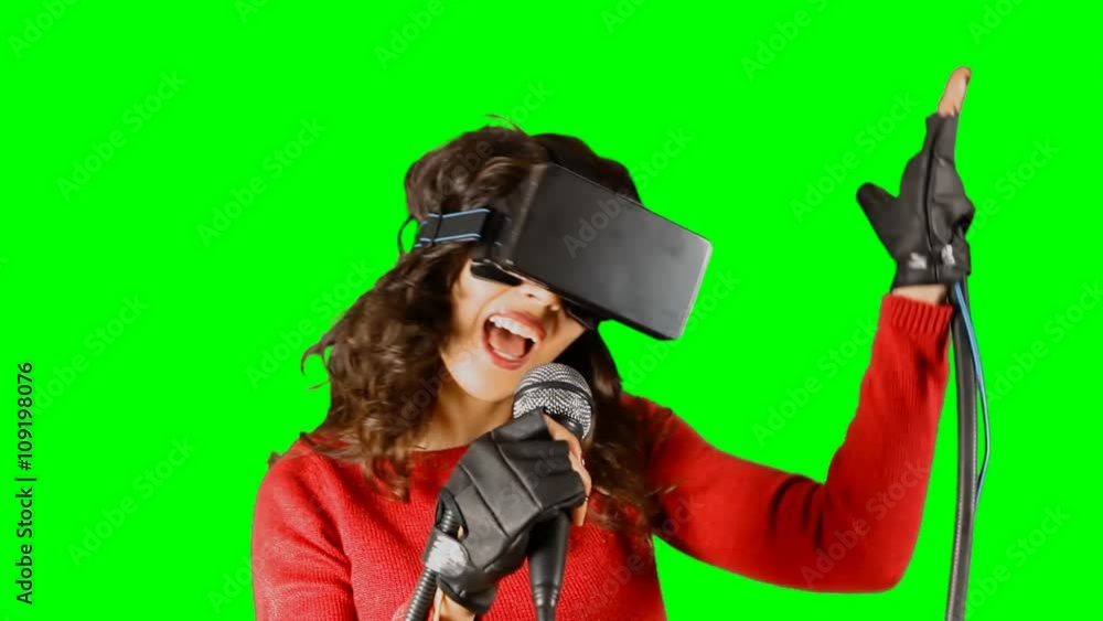 A girl wearing a virtual reality headset and wired gloves, singing with a microphone. Pre-keyed chroma-key shot. A girl wearing a virtual reality headset and wired gloves, singing with a microphone. Pre-keyed chroma-key shot.