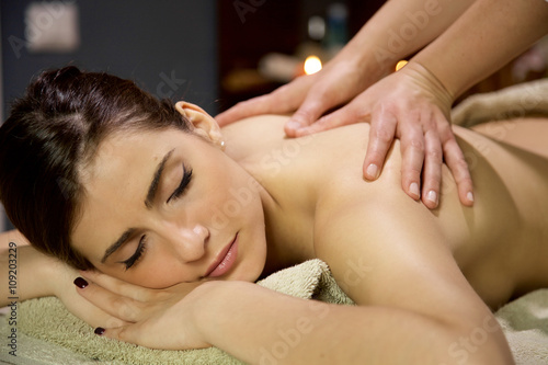 Beautiful woman relaxing in spa getting massage in vacation