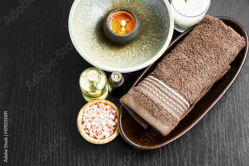 Spa setting with towel, candle, salt and body-oil