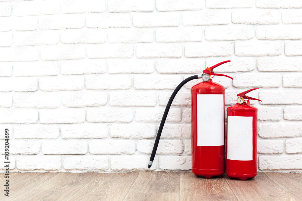Fire extinguisher near white wall, ready for use Fire extinguisher near white wall, ready for use
