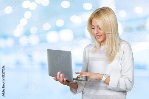 Smiling mature woman holding laptop