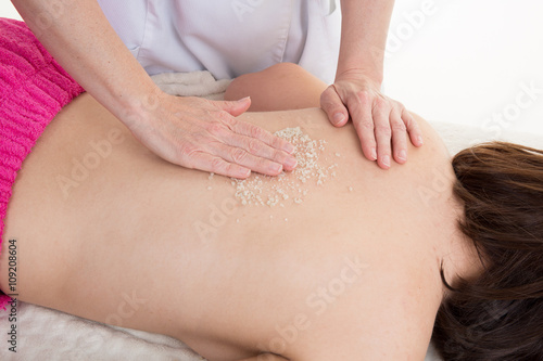 Woman is doing a salt scrub massage at spa
