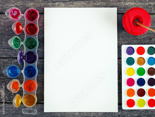 Watercolor paints set with brushes and paper sheet