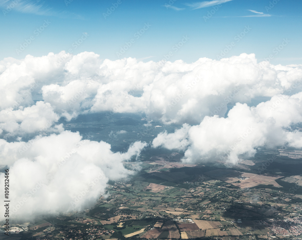 Aerial view of clouds and landscape under them.