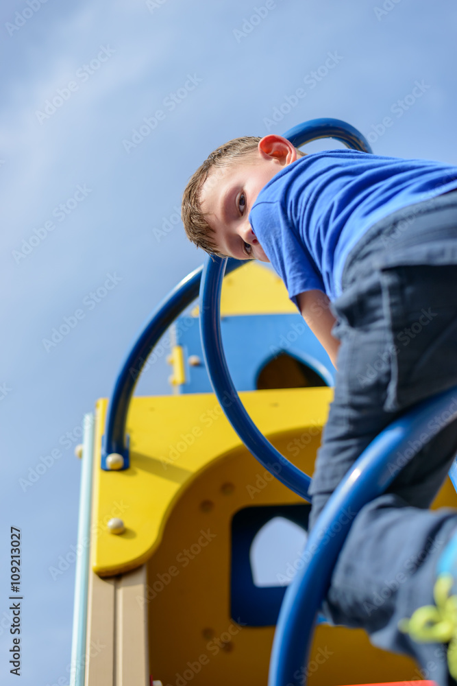 Low angle view on boy climbing pole Low angle view on boy climbing pole