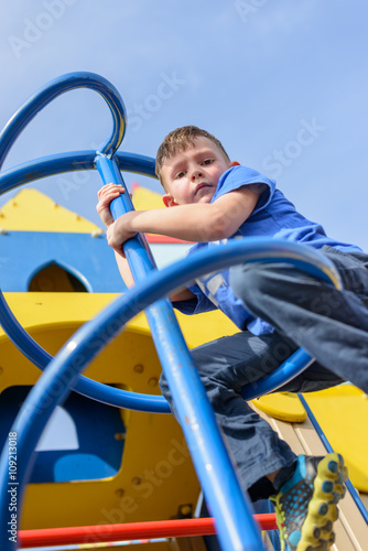 Low angle view on boy climbing pole