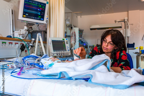 Mother and child in intensive care unit after heart surgery.