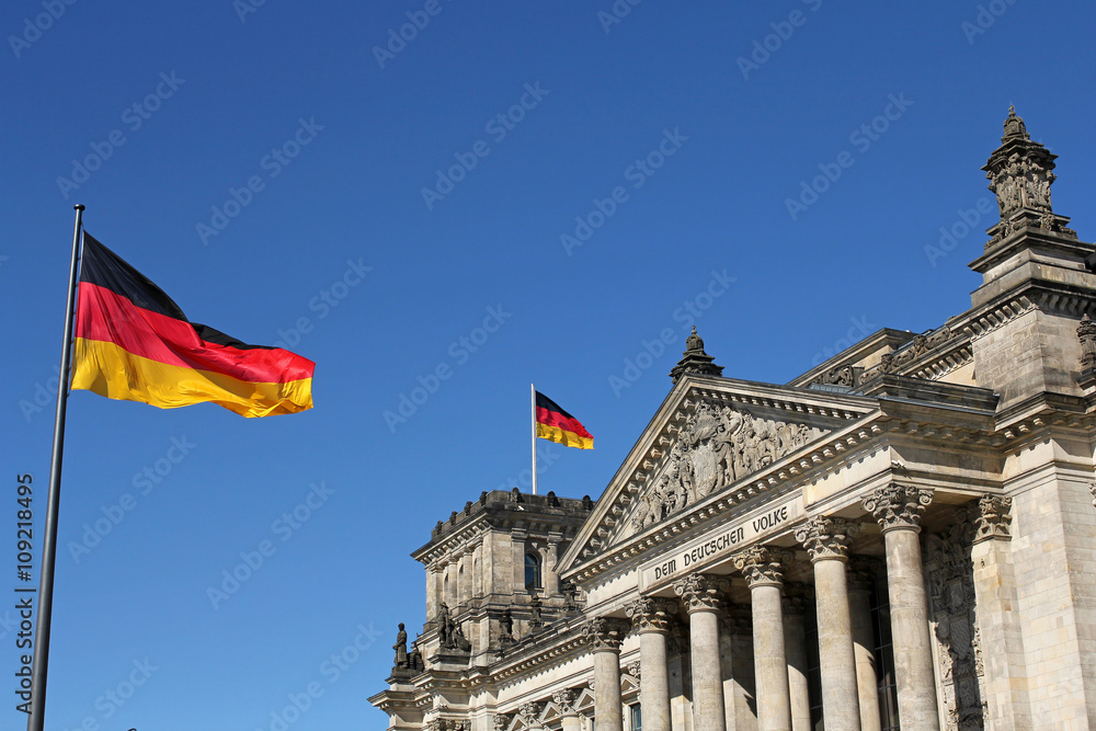 Naklejka premium German flags and Reichstag building in Berlin, Germany