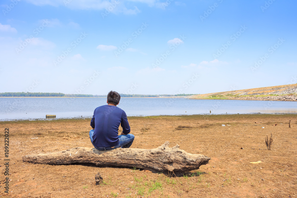 A man sitting lonely on beach.