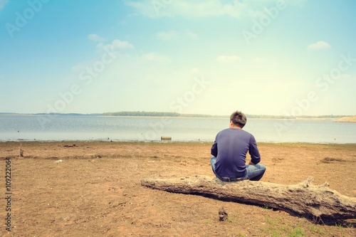 A man sitting lonely on beach.