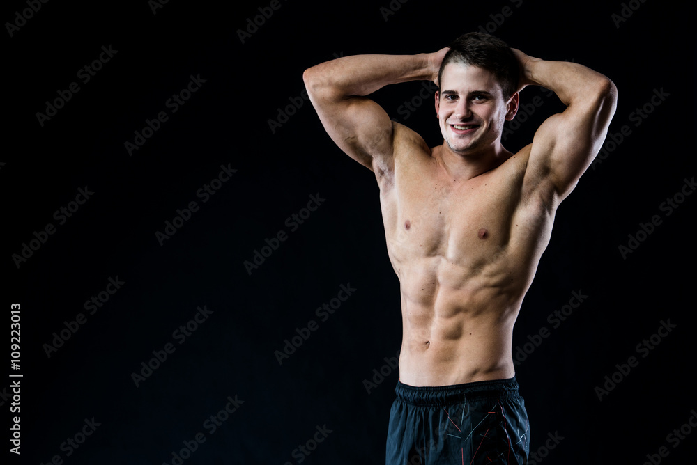 Shirtless man in shorts looking to the camera with his hands on top of head Shirtless man in shorts looking to the camera with his hands on top of head