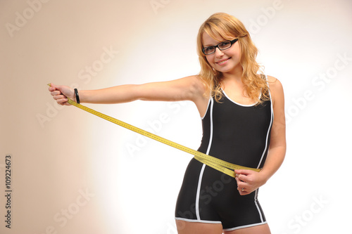 Sportive blonde girl with measuring tape