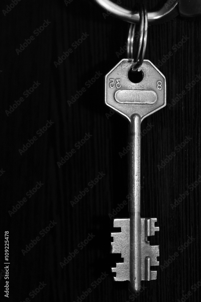 Iron key on dark background, black and white photo