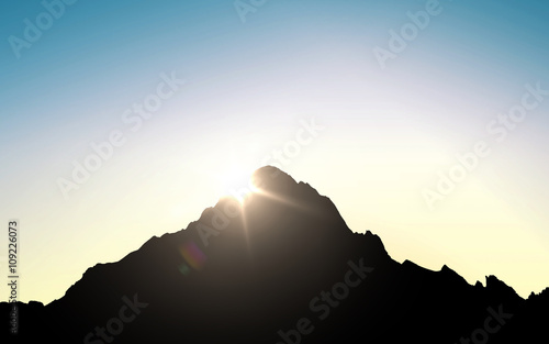 silhouette of mountain top over sky and sun light