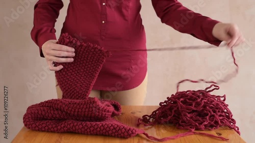 Woman unravelling the red scarf