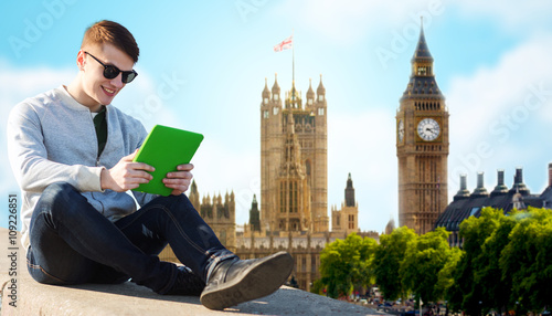 Canvas Print happy young man with tablet pc over london city