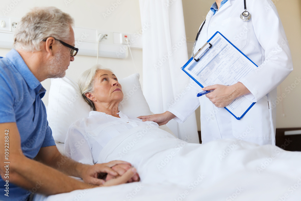 Fototapeta premium senior woman and doctor with clipboard at hospital