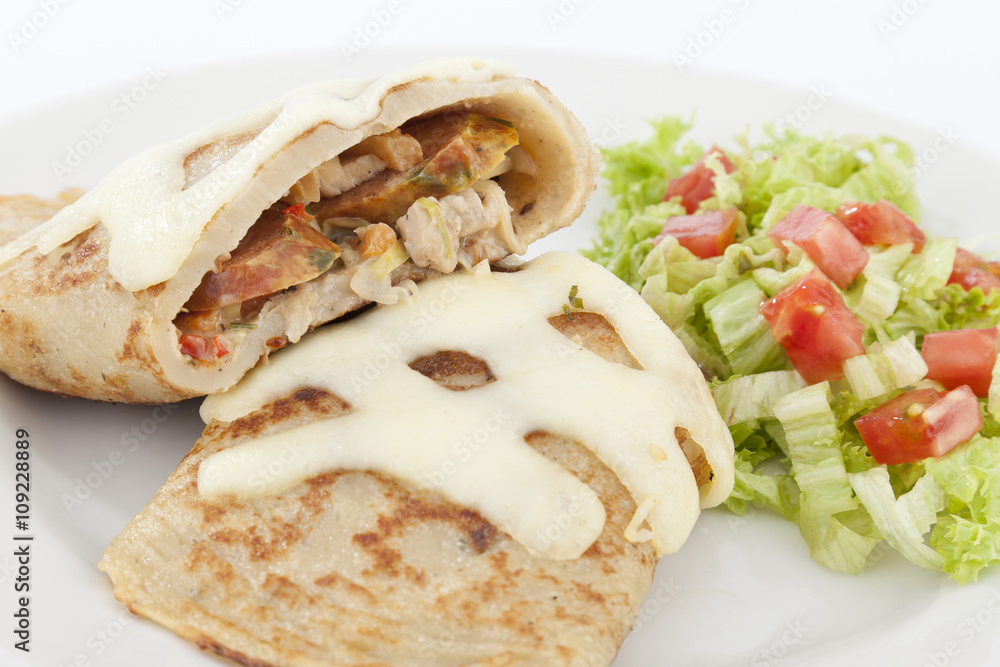 Delicious burrito brunch of sausage cut in half on white plate Delicious burrito brunch of sausage cut in half on white plate
