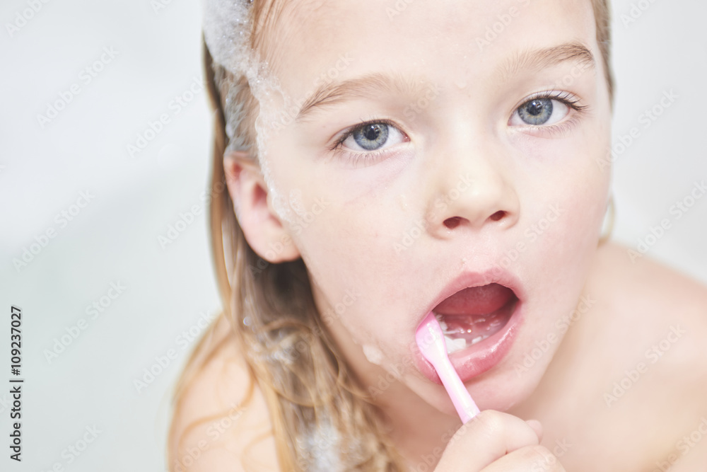 Dental hygiene. Close up of little girl brushing her teeth. Fun in the bath Dental hygiene. Close up of little girl brushing her teeth. Fun in the bath