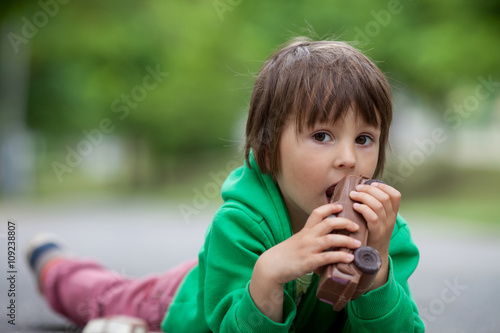 Funny little boy playing with car of chocolate  outdoor