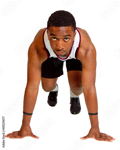 Male track runner in starting position isolated on white background.
