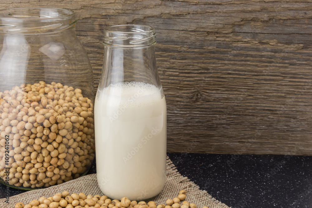 Soybeans and bottle of soy milk, on wooden background. Soybeans and bottle of soy milk, on wooden background.