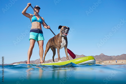 Woman paddle-boarding with dog