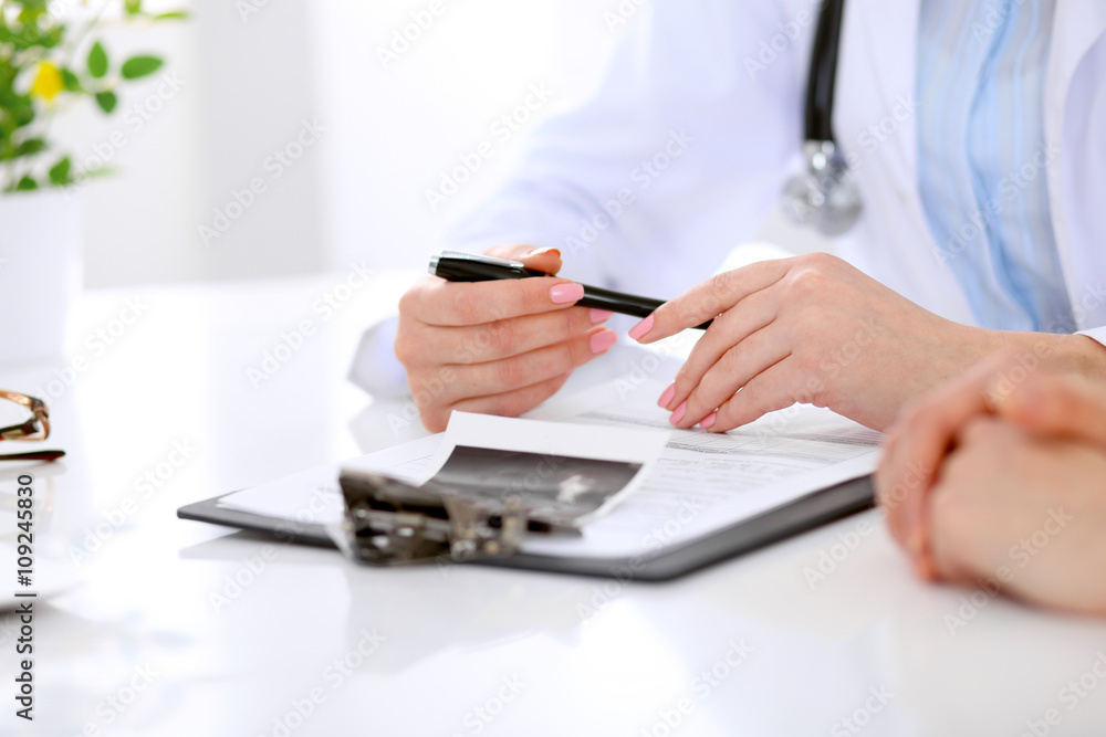 Fototapeta premium Doctor and patient are discussing something, just hands at the table