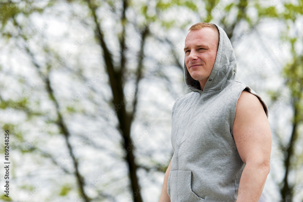 Workout man in hood resting. Outdoor. Workout man in hood resting. Outdoor.